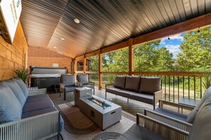 Un espace extérieur abrité, équipé d’un barbecue, de sièges et offrant une vue sur le paysage.