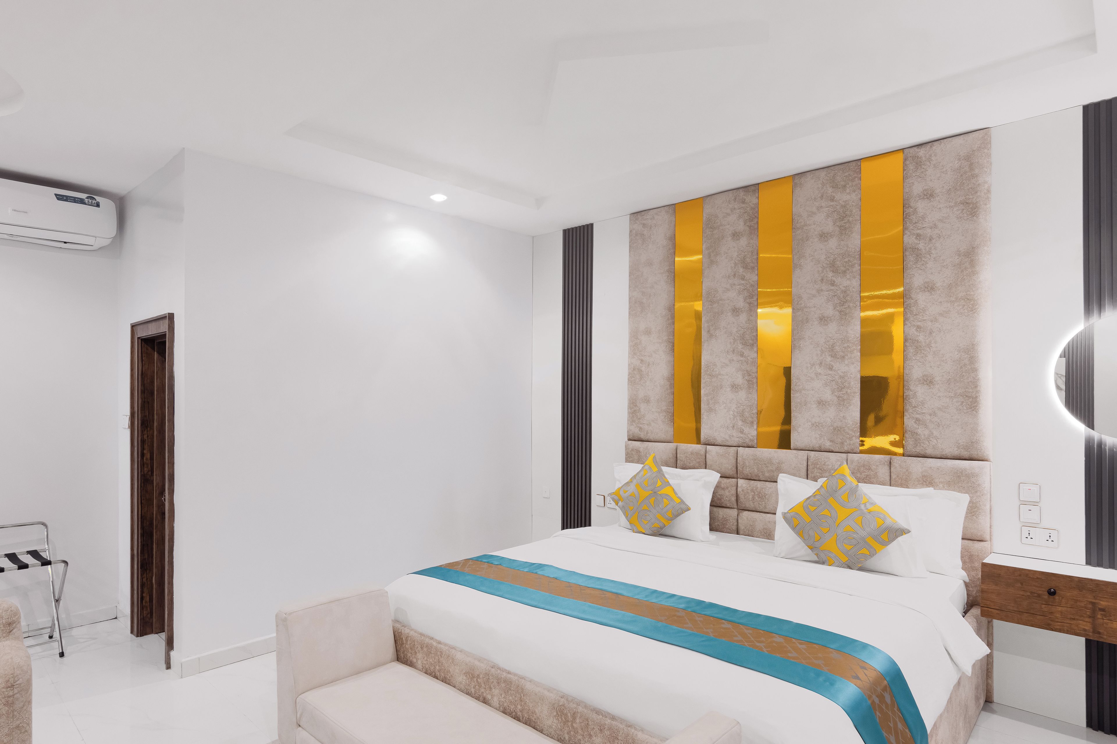 Un dormitorio moderno con una cama grande, mesitas de noche y un espejo integrado.
