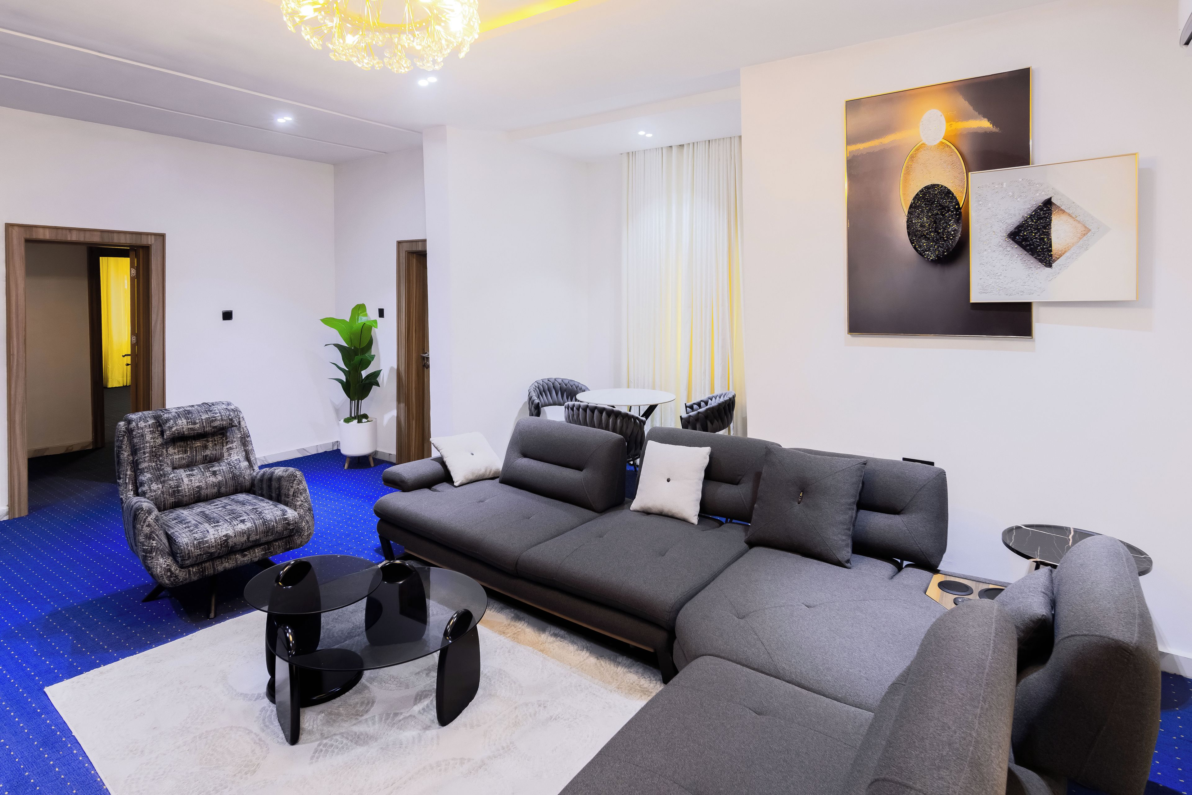 A modern living room with a sectional sofa, a round coffee table, and a patterned rug.