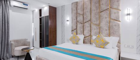 A modern bedroom with a large bed, bedside tables, a wardrobe, and an air conditioning unit.