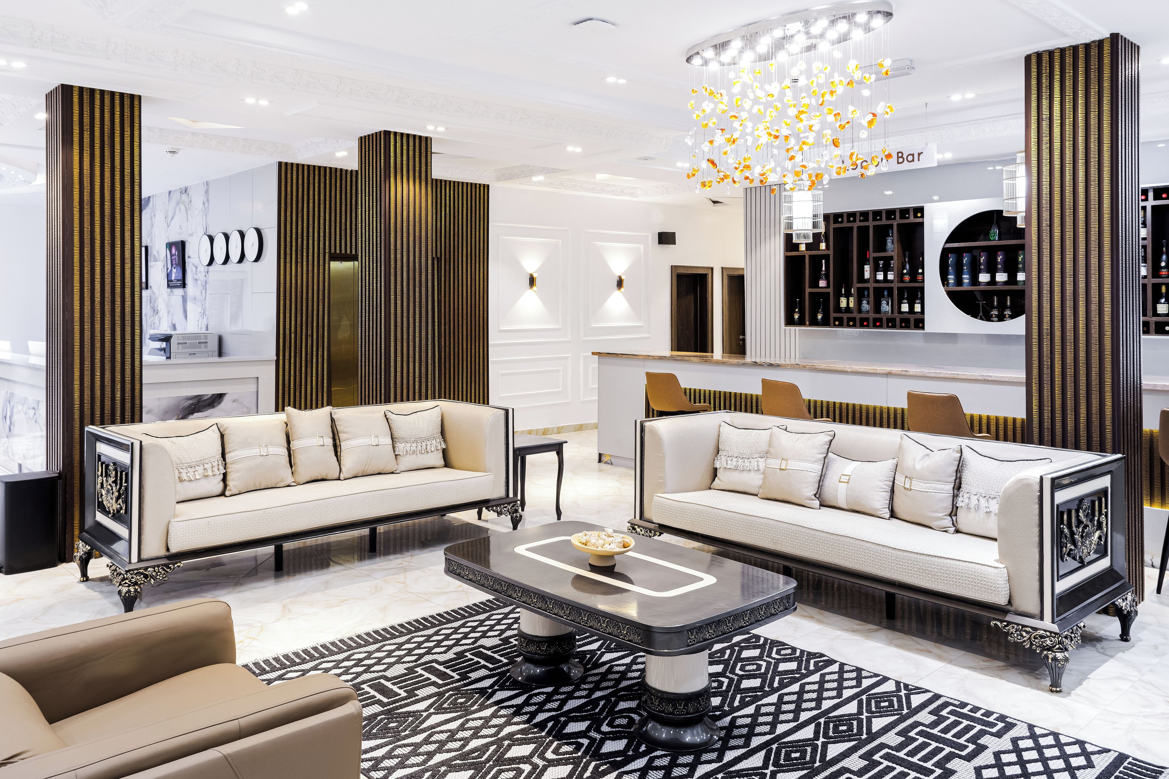 A modern living room with two sofas, a coffee table, and a bar area with shelves.