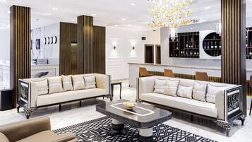 A modern living room with two sofas, a coffee table, and a bar area with shelves.