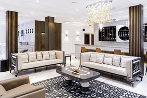 A modern living room with two sofas, a coffee table, and a bar area with shelves.