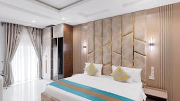A modern hotel room with a large bed, bedside tables, a wardrobe, and a bathroom with a shower.
