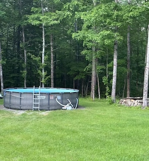 A rectangular pool with a ladder and filtration system, surrounded by a grassy area and trees. - RV camp site great area to hunt, fish, boat, relax


with AC (Mercer)