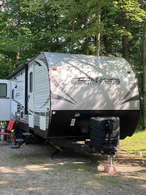 A large RV with a covered living area, a kitchen, and a bathroom. - RV camp site great area to hunt, fish, boat, relax


with AC (Mercer)