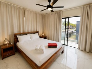 A hotel room with a large bed, a ceiling fan, and a view of the outdoors. - Private Pool Villa 3BR | Gated, 10 Min Downtown (Punta Cana)