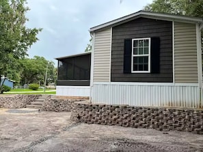 A two-story house with a brick foundation and a screened porch. - Quiet country setting, river retreat dunnellon (Dunnellon)