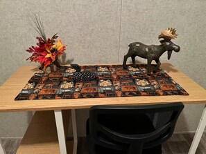 A table with a patterned placemat, a decorative vase with autumn leaves, and a moose figurine. - Quiet country setting, river retreat dunnellon (Dunnellon)