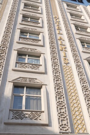 A hotel facade with multiple windows and decorative architectural elements. - Alkış Otel (Igdir)