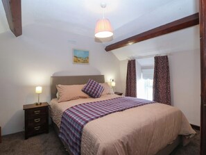 A bedroom with a bed, bedside tables, a lamp, a painting, and curtains. - Pant (Llanfairpwllgwyngyll)