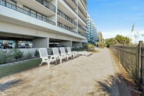 A multi-story hotel with outdoor seating and a covered parking area. - Luxury 2/2 Oceanfront at Sea Winds PH8 (North Myrtle Beach)