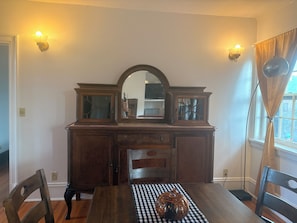 Ein Esszimmer mit Holztisch, Stühlen, einer karierten Tischdecke und einer dekorativen Kürbis-Dekoration.
