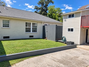 A residential property with a well-maintained lawn, a wooden fence, and a concrete driveway. - Oak & Ash | Lindale Park Houston (Houston)
