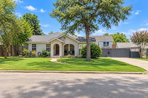 A single-story house with a front porch, a driveway, and a well-maintained lawn. - Oak & Ash | Lindale Park Houston (Houston)