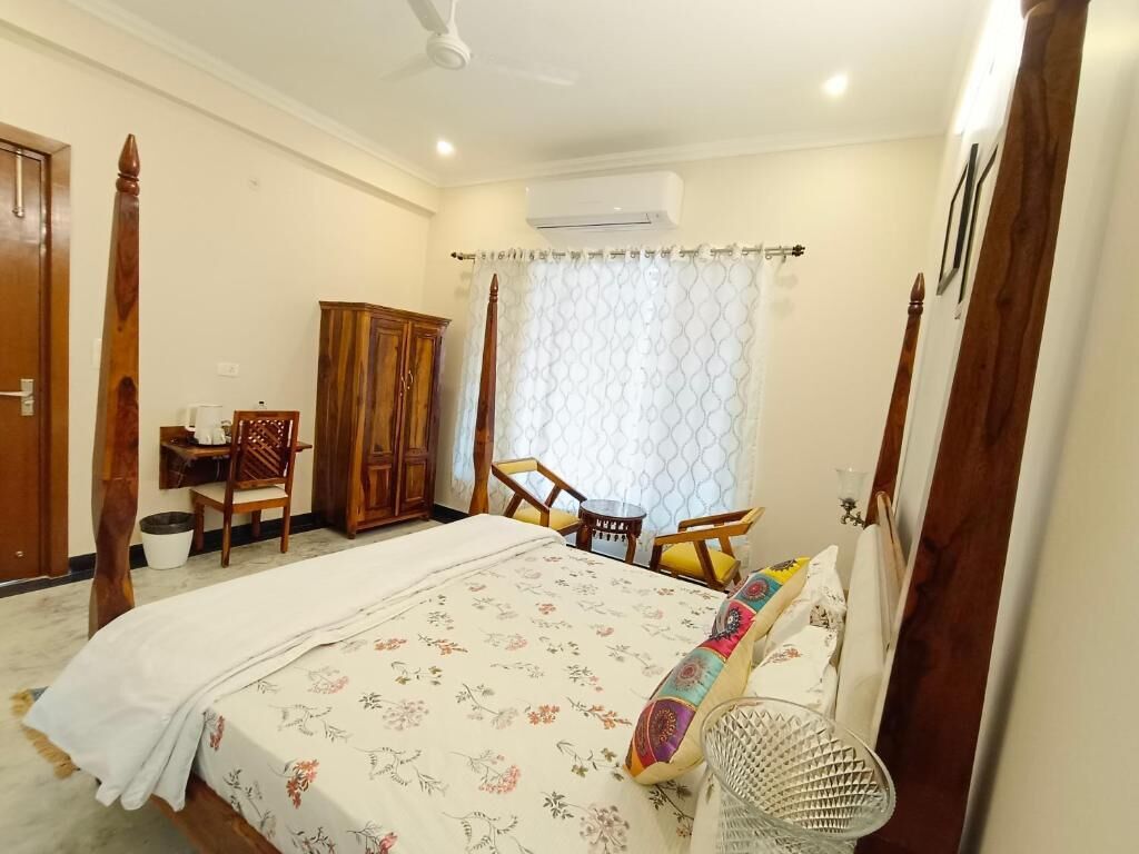 A bedroom with a bed, a desk, and a chair.