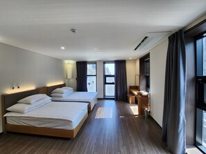 A hotel room with two beds, a desk, a mirror, and a large window. - seombadi hotel (Ulleung)