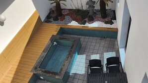 Área de piscina en la azotea con una piscina pequeña, asientos y plantas.