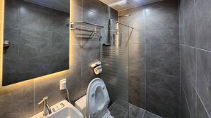Un baño moderno con inodoro, lavabo y zona de ducha.