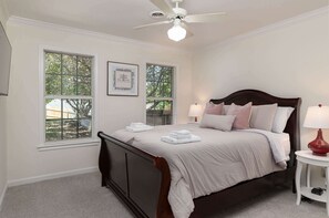 A bedroom with a bed, two windows, a ceiling fan, and a bedside table with a lamp. - Tanner Drive Getaway | Pet Friendly (Oxford)