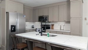 A modern kitchen with a central island, stainless steel appliances, and a bar stool seating area. - Tanner Drive Getaway | Pet Friendly (Oxford)