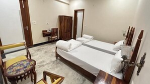 Ein Schlafzimmer mit einem Bett, zwei Stühlen, einem kleinen Tisch und einem Kleiderschrank.