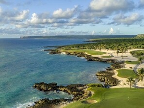 Ein Küsten-Golfplatz mit Blick auf das Meer und eine ferne Klippe.