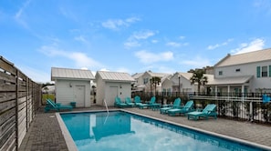A swimming pool with lounge chairs, a wooden fence, and white buildings with green shutters. - 🦀Seabreeze | Walk to Beach | Community Pool | 3BR🌅 (Panama City Beach)