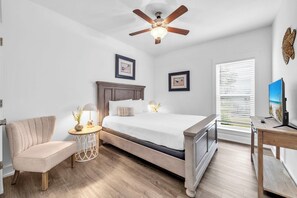 A bedroom with a bed, a chair, a table with a lamp, a ceiling fan, and a window with blinds. - 🦀Seabreeze | Walk to Beach | Community Pool | 3BR🌅 (Panama City Beach)