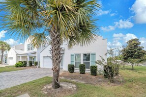 A modern two-story house with a driveway, a palm tree, and a well-maintained lawn. - 🦀Seabreeze | Walk to Beach | Community Pool | 3BR🌅 (Panama City Beach)