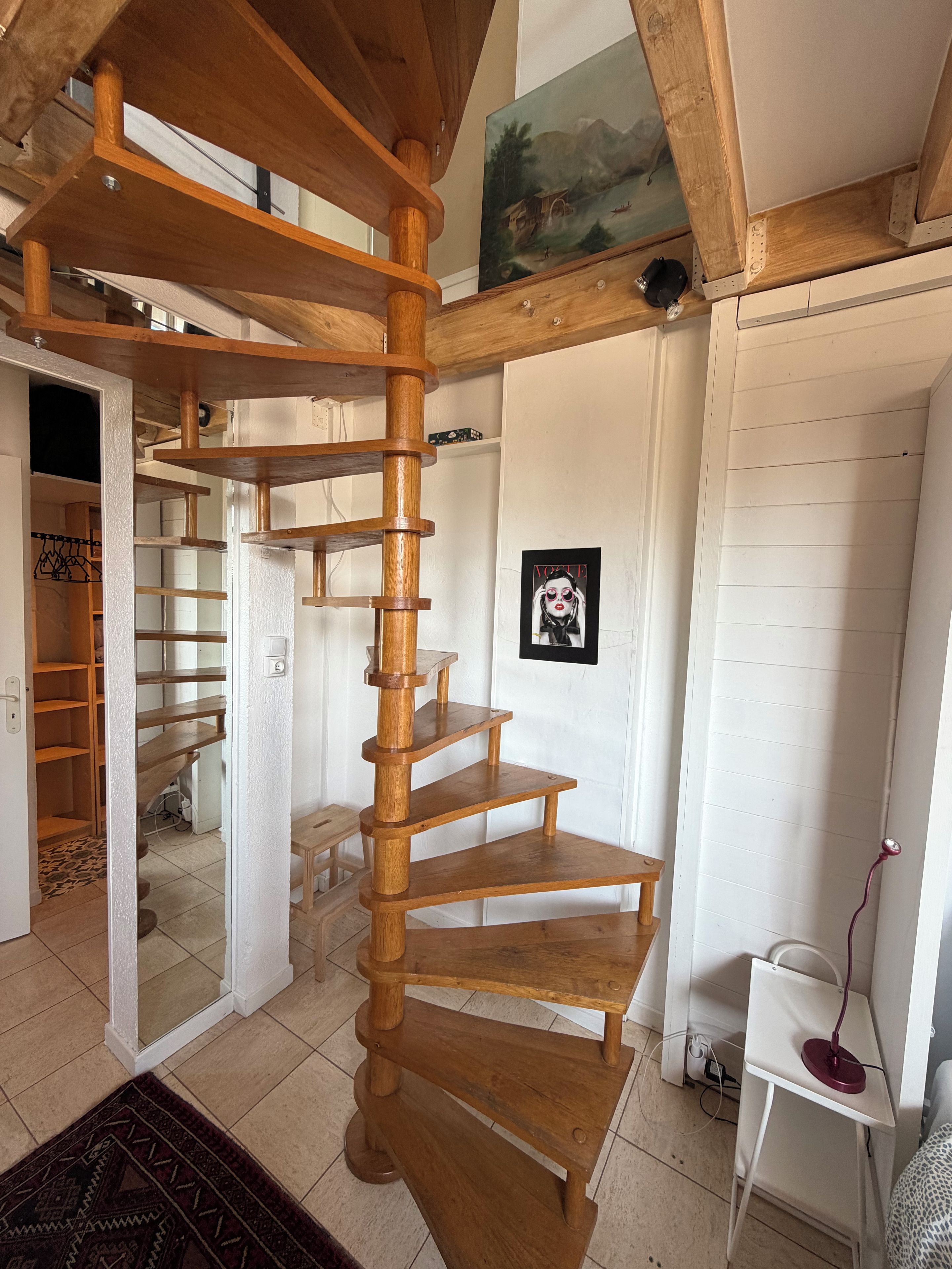 Una scala a chiocciola con gradini in legno e interni bianchi.