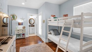 A bedroom with bunk beds, a dresser, a mirror, and a door with a circular mirror. - 🌴 Little Bird’s Nest | 4BR | Near Beach | Community Pool | 30A 🏖️ (Santa Rosa Beach)