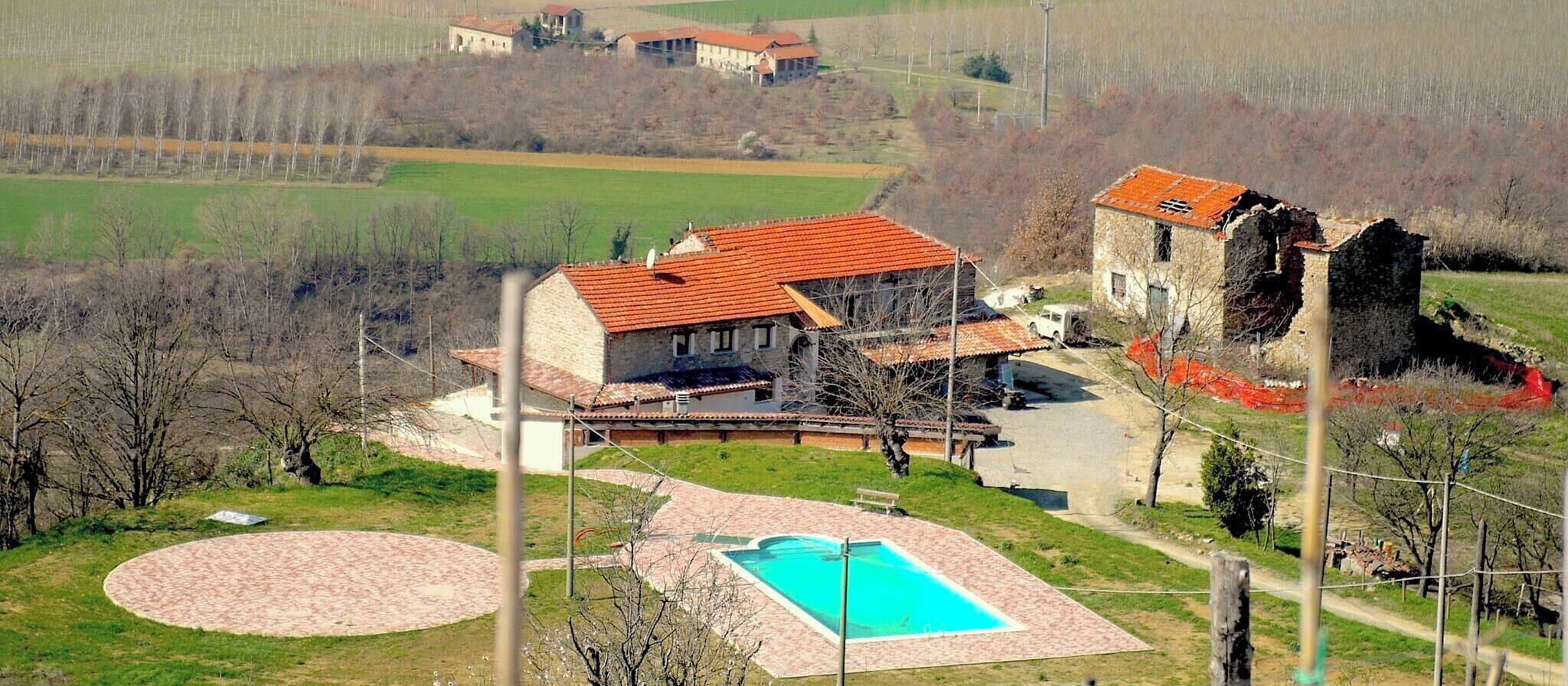 Une propriété résidentielle dotée d’une piscine, d’un court de tennis et d’un bâtiment en pierre.