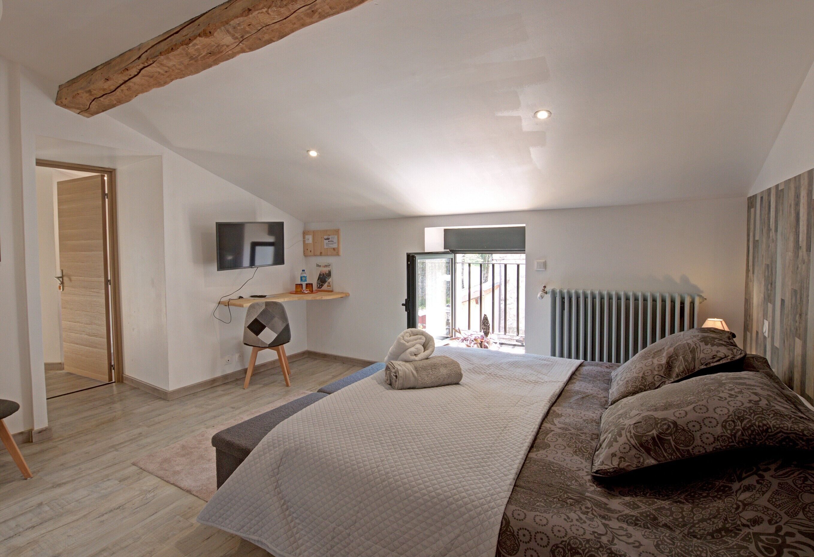 Une chambre à coucher comprenant un lit, un bureau, une chaise, un radiateur et un téléviseur.