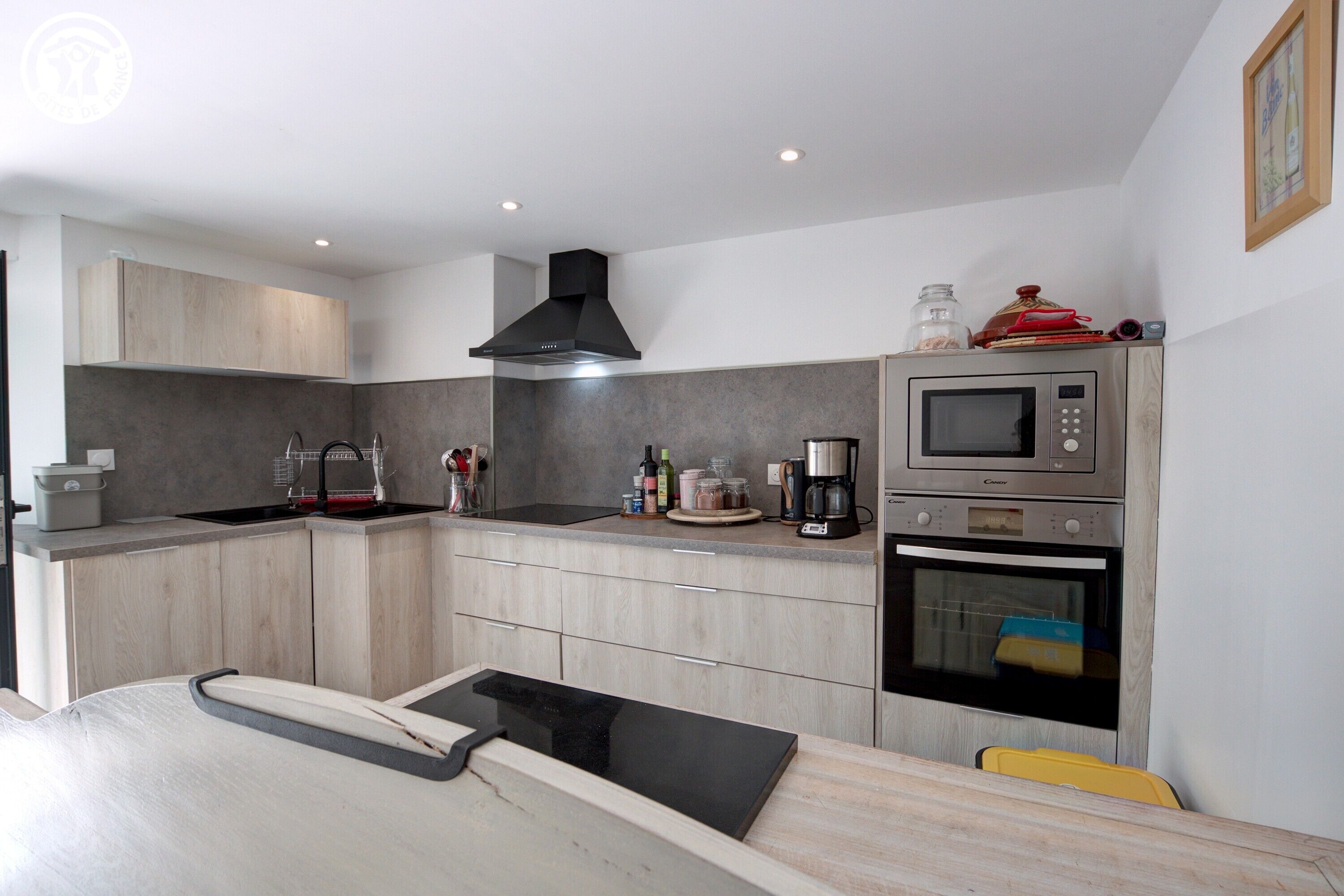 A modern kitchen with a built-in microwave, oven, and coffee maker.