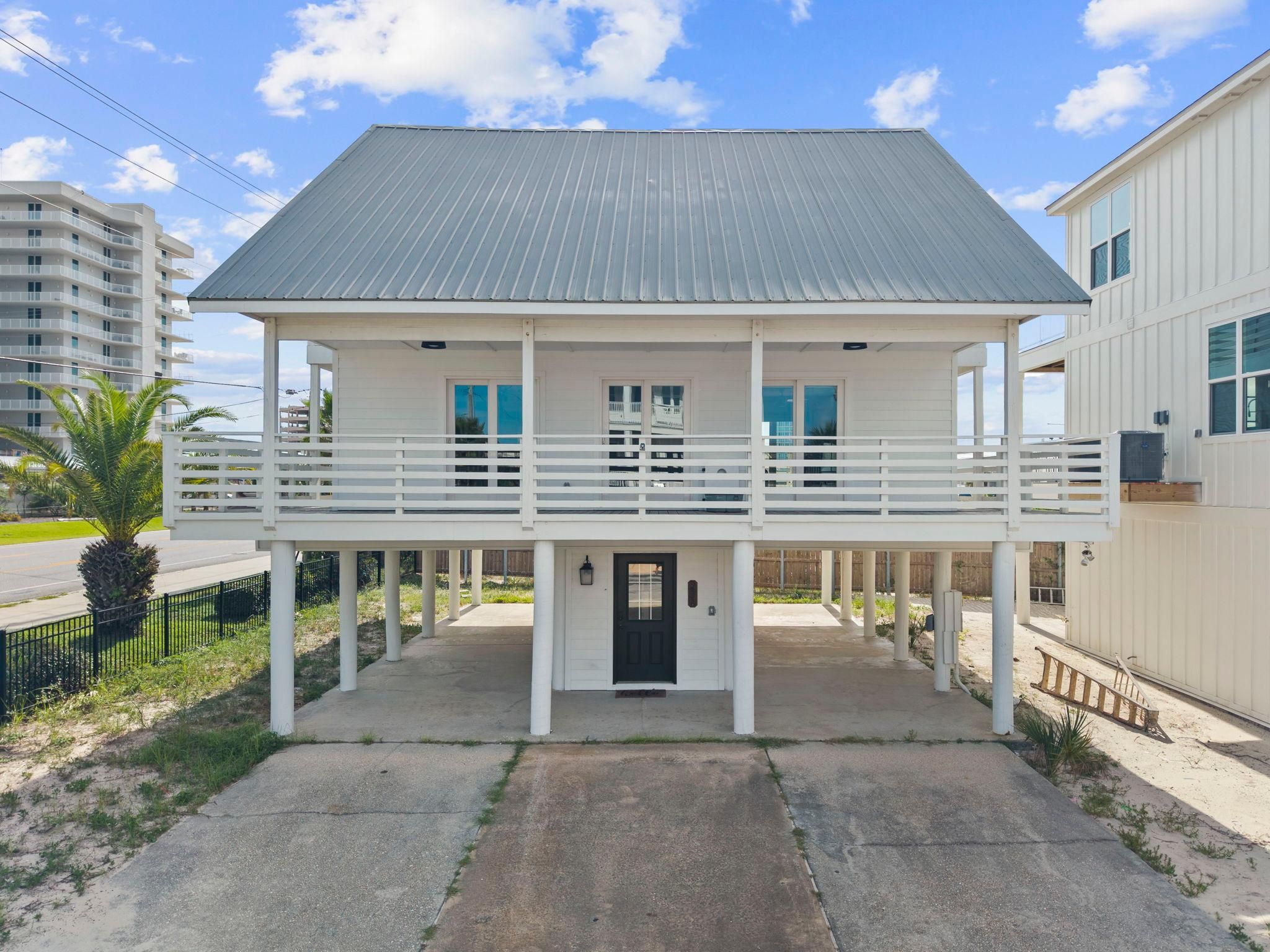 A two-story building with a balcony, a front door, and a small porch area.
