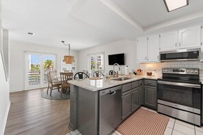 Una cocina moderna con una isla central, electrodomésticos de acero inoxidable y un comedor con vistas.