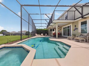 A swimming pool with a covered patio area, outdoor furniture, and a view of the surrounding landscape. - Sunset to Magic 6BR Davenport Home with Private Pool Near Disney (Davenport)