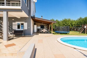 A modern house with a swimming pool, outdoor seating, and a trampoline. - Villa Odzakovic - Four Bedroom Villa, Sleeps 8 (Nadin)
