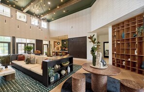 Uma sala de estar ampla com sofá, mesa de centro e estante de livros.