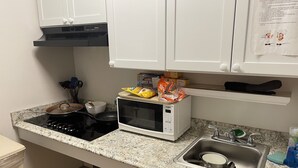 A kitchen with a stove, microwave, sink, and cabinets. - Danna apartment  (Crested Butte)