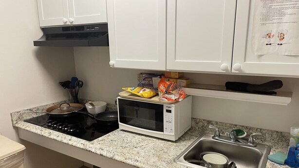 A kitchen with a stove, microwave, sink, and cabinets. - Danna apartment  (Crested Butte)