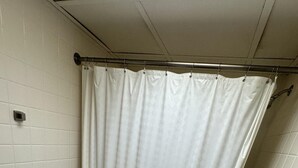 A bathroom with a white bathtub, a shower curtain, and tiled walls. - Danna apartment  (Crested Butte)