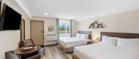 A hotel room with two beds, a desk, a chair, a TV, and a window with a view.