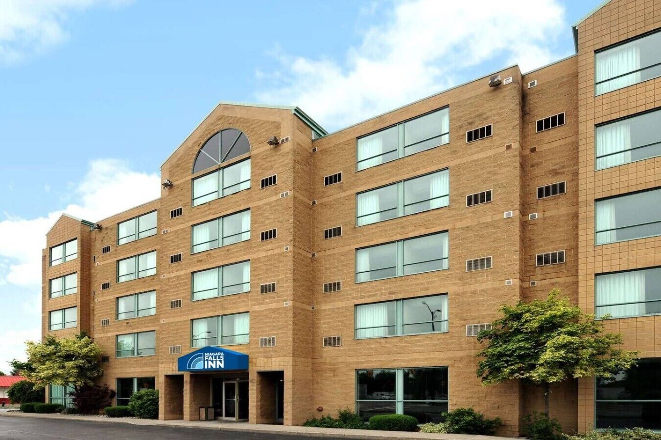 A multi-story brick building with a prominent entrance and a sign for Niagara Falls Inn.