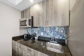 A kitchen with wooden cabinets, a microwave, a coffee maker, and a sink. - Central Studio~9 Min drive 2 FALLS+Clifton Hill! (Niagara Falls)