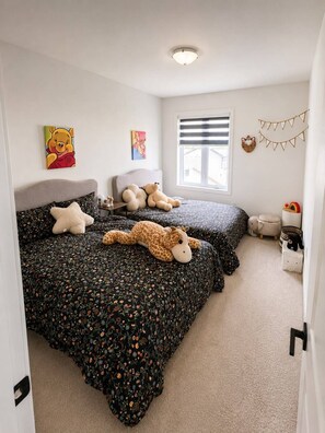 A bedroom with two beds, a window with blinds, and wall decorations including a Winnie the Pooh painting. - Cozy home in London (London)