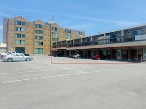 A multi-story building with a parking lot in front. - 9 min drive to Falls! Tropical Studio Apartment (Niagara Falls)