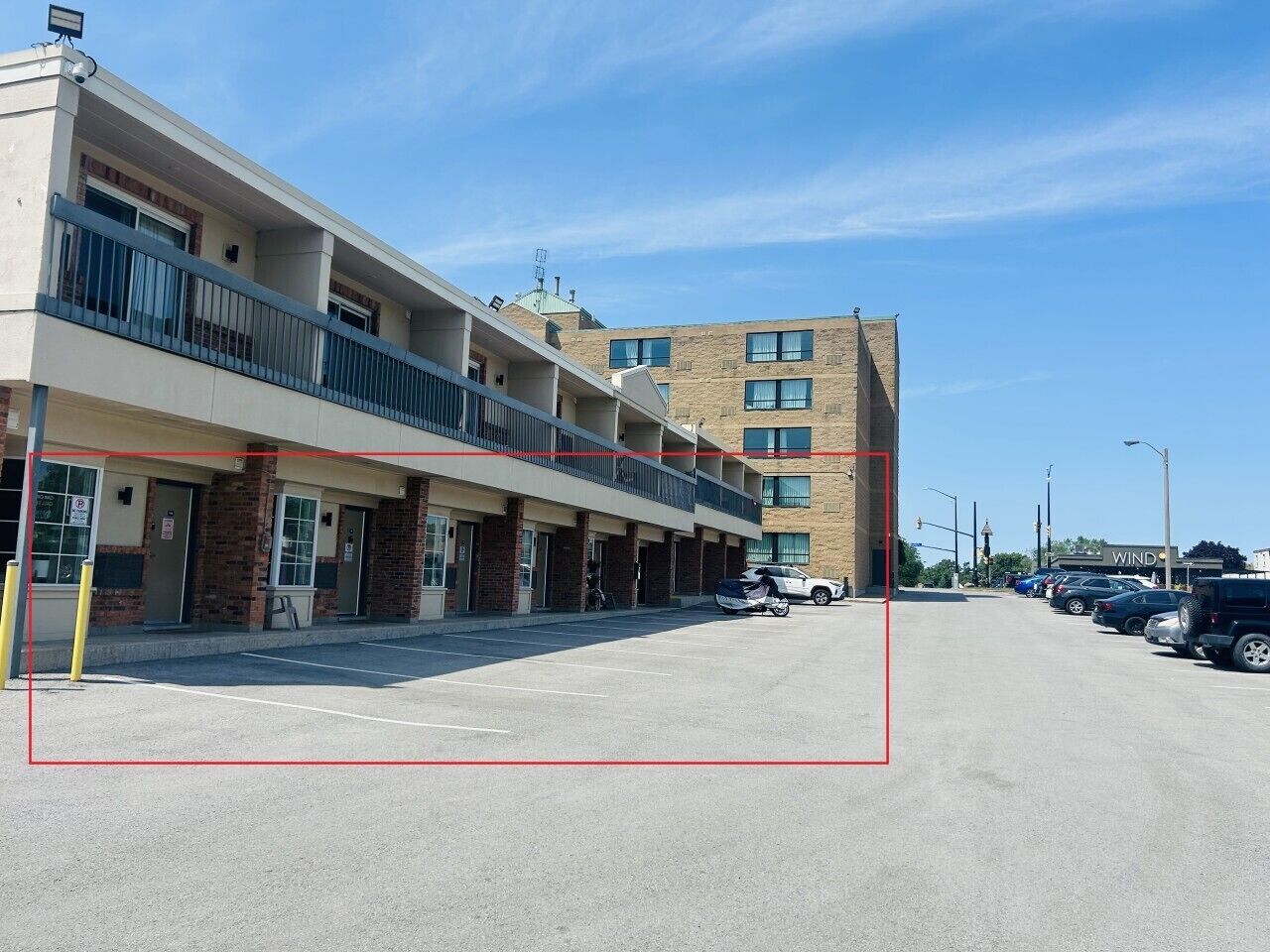 Un parking à étages doté d’une galerie couverte et d’un bâtiment en arrière-plan.