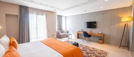 Une chambre d’hôtel avec un lit, un bureau, une chaise, une télévision et une lampe.
